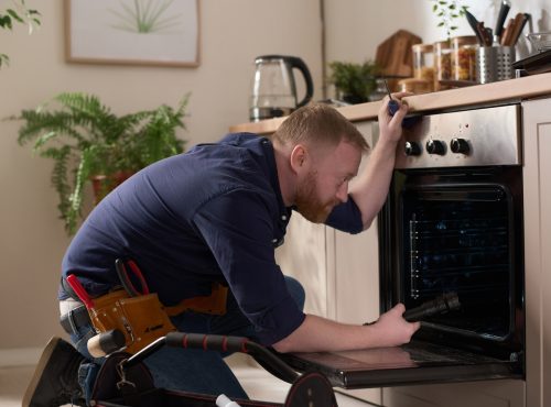 worker-repairing-oven-at-home-XTNJLT4